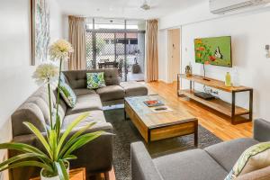 a living room filled with furniture and a large window at Cascade Gardens in Cairns