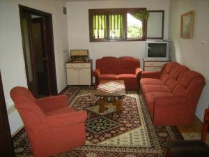 ein Wohnzimmer mit 2 roten Stühlen und einem TV in der Unterkunft Apartment Stefano - Center, Ohrid in Ohrid