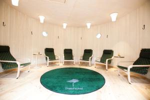 a waiting room with chairs and a green rug at Treehotel in Harads