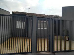 a black fence with a gate in front of a building at Recanto ferreira in Olímpia