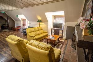 a living room with yellow furniture and a fireplace at Gold Mine Guest House and Cafe in Nundle
