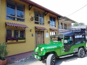 a green jeep parked in front of a house at Hotel La Caracola Salento in Salento