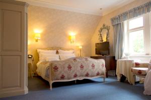 a bedroom with a bed and a television in it at Corriegour Lodge Hotel in Spean Bridge