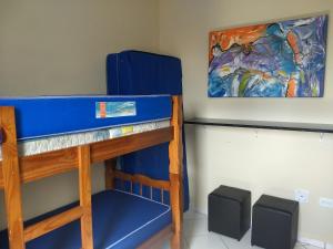 蒙加瓜的住宿－Apto Verde Água，墙上画作的宿舍间内的一张双层床
