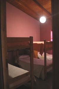 Habitación con 2 literas y luz. en Hostel Rogupani en San Rafael