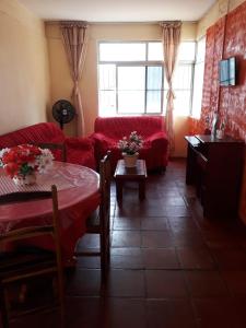sala de estar con sofá rojo y mesa en Apartamento Ed Jany Fortaleza, en Fortaleza