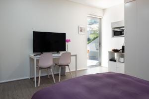 Schlafzimmer mit einem Schreibtisch, einem TV und 2 Stühlen in der Unterkunft Hideaway Haven, The Cute Place To Put Up Your Feet in Sydney