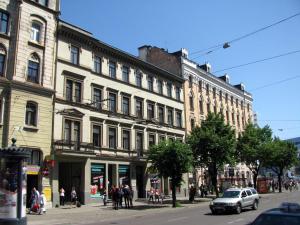 un grand bâtiment dans une rue de la ville avec des gens sur le trottoir dans l'établissement AntiK Apart Hotel, à Riga