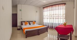 a bedroom with a bed and a red table at Harry Inn in Negombo