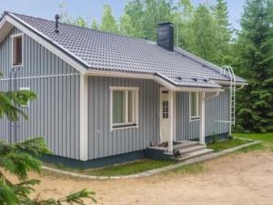 a small grey house with a porch at Holiday Home Lokki by Interhome in Vesijako