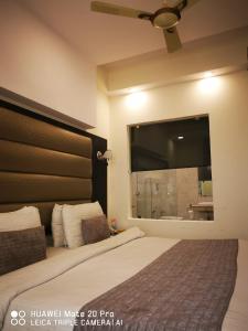 ein Schlafzimmer mit einem großen Bett und einem großen Spiegel in der Unterkunft Hotel PK Residency in Noida