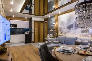a living room with a dining room table and a kitchen at Zakopane FIVE STARS in Zakopane