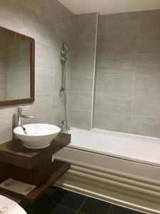 楠梓區的住宿－花鄉旅館連鎖-楠梓店 ，浴室配有盥洗盆和浴缸。