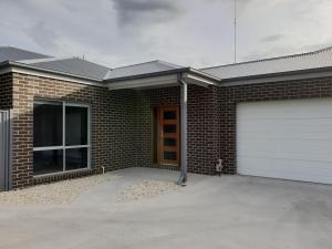 a brick house with a white garage door at 123 Wilson - Arapiles in Horsham