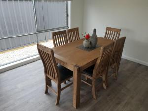 a wooden table with four chairs and a vase on it at 123 Wilson - Arapiles in Horsham