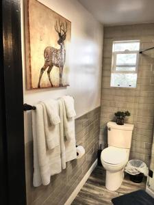 baño con aseo y una foto de un ciervo en Papillon Cellars - The Loft, en Mariposa