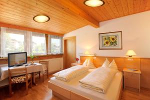 Dormitorio con cama, escritorio y TV en Gasthof Anich en Naz-Sciaves