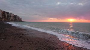 a sunset on a beach with the ocean at Gîte le tréportais in Le Tréport +16 photos
