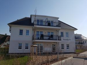 a large white house with a black roof at FeWo Baltic Sky in Börgerende-Rethwisch
