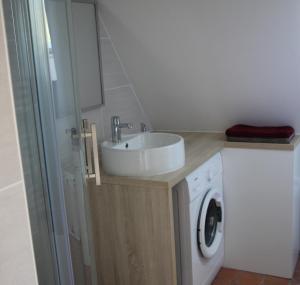 a bathroom with a sink and a washing machine at Gite du Moulin de Balzac in Artannes-sur-Indre