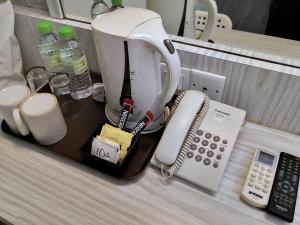 a coffee maker and a phone on a counter at Hotel Westree KL Sentral in Kuala Lumpur