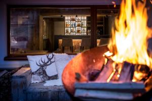 a fire pit in a living room with flames at Hotel Des Alpes in La Villa