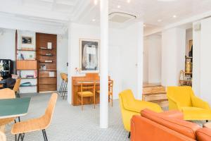 un salon avec des chaises jaunes et une table dans l'établissement Hôtel Lucien, à Paris