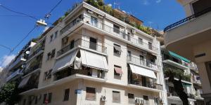 un alto edificio bianco con balconi e piante di Filos Apt. under Acropolis ad Atene