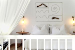 Dormitorio blanco con cama con almohadas blancas en Kostantakis Residence & Winery, en Pollonia