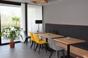 uma sala de jantar com mesas de madeira e cadeiras amarelas em Garden-Suite Faselehof em Marlengo