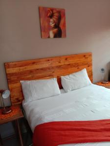 a bedroom with a large bed with a wooden headboard at Tap's Home Away from Home in Gaborone