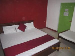 a bedroom with a bed with a red and green wall at Tree House Holiday Home in Bandarawela