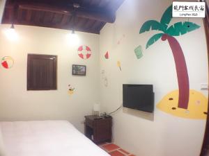 a bedroom with a bed with a palm tree on the wall at Longmen Inn Bed and Breakfast in Jinning