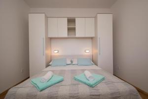 a bedroom with a bed with two pillows on it at Apartments Mirna in Korčula