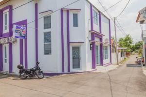 a motorcycle parked in front of a purple and white building at RedDoorz Plus @ Tuparev Cirebon 2 in Cirebon