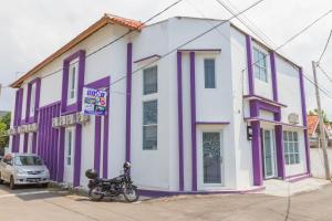 a motorcycle parked in front of a purple and white building at RedDoorz Plus @ Tuparev Cirebon 2 in Cirebon