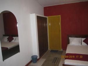 a bedroom with two beds and a yellow door at Tree House Holiday Home in Bandarawela +10 photos
