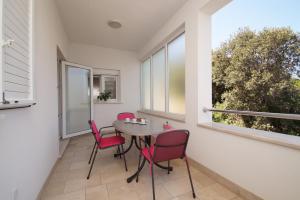 a balcony with a table and chairs and a window at Apartments Mirna in Korčula
