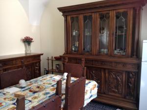 a dining room with a table and a large wooden cabinet at Casa vacanze da Medardo in Gagliano Aterno