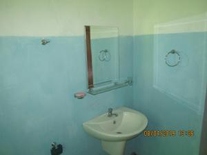 a bathroom with a white sink and a mirror at Tree House Holiday Home in Bandarawela