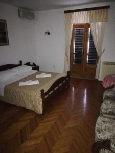 a bedroom with a bed and a wooden floor at Villa Kukuljica in Zaton