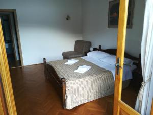 a small bedroom with a bed and a chair at Villa Kukuljica in Zaton
