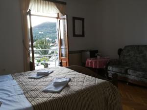 a room with a bed and a couch and a window at Villa Kukuljica in Zaton