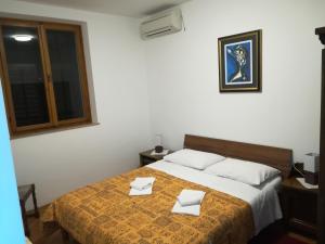 a bedroom with a bed with two white towels on it at Villa Kukuljica in Zaton