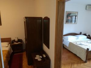 a small bedroom with a bed and a mirror at Villa Kukuljica in Zaton