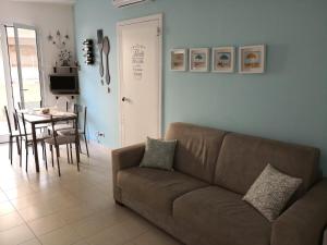 een woonkamer met een bank en een tafel bij Casa Vittoria in Marina di Ragusa