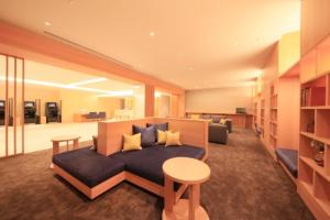 ein Wohnzimmer mit einem Sofa und einem Tisch in der Unterkunft Richmond Hotel Tenjin Nishi-Dori in Fukuoka