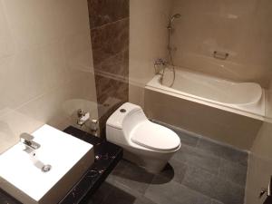a bathroom with a toilet and a sink and a tub at The Surya Kuta Villa in Kuta