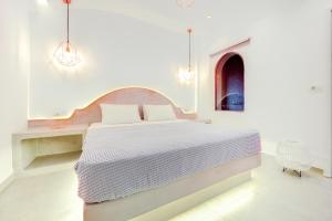 biała sypialnia z łóżkiem i stołem w obiekcie Emerald Collection Suites w mieście Karterados