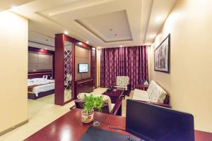 a hotel room with a desk and a bedroom at Dunhuang Gold Dragon Hotel in Dunhuang